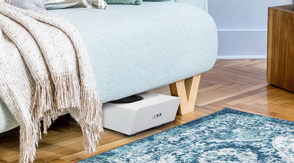 Bluesound Pulse Sub Plus белого цвета под диваном в гостиной — компактные размеры позволяют скрытую установку