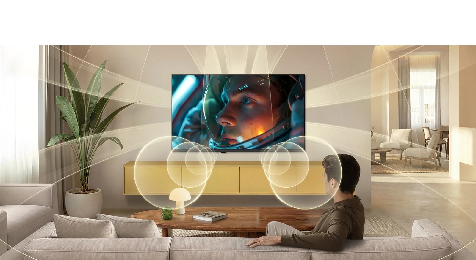 Телевизор LG SMART TV AI LB65 с виртуальными каналами 9.1.2 на базе умного звука наполняет современную гостиную разнонаправленным звуком во время просмотра на экране сцены из фильма про астронавтов, усиливая эффект погружения во всем пространстве.
